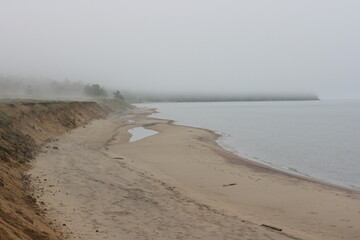 Foggy landscape on the shore of Baikal Lake. Olkhon Island in rainy and foggy weather. Summer unusual landscape.