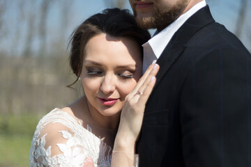 close-up portrait Young wedding couple of the groom with the bride kissing, cuddling, on a natural background. Summer wedding.