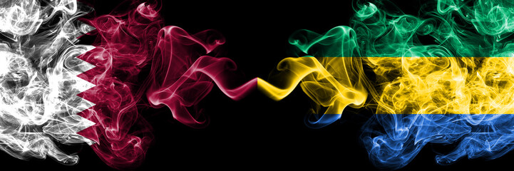 Qatar vs Gabon, Gabonese smoky mystic flags placed side by side. Thick colored silky abstract smoke...