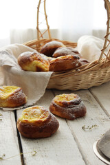 Fresh cheesecakes in a basket on a wooden table in the sun. Homemade cake. Confectionery.