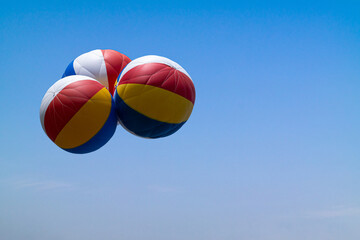 a colorful balloon floating in a cloudless blue sky.