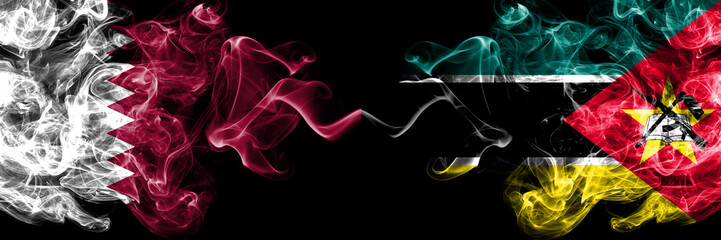 Qatar vs Mozambique, Mozambican smoky mystic flags placed side by side. Thick colored silky abstract smoke flags.