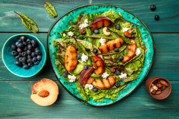 Vibrant grilled peach salad with blueberries and creamy goat cheese, Summer salad with fruits and berries