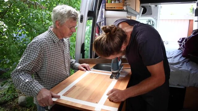 Man and his father working together on a camper van conversion