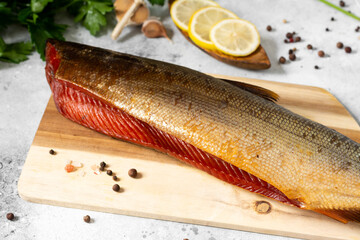 Sockeye salmon. Sockeye salmon on a serving board on a light gray kitchen table. Smoked sockeye salmon on a serving board