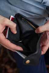 men's hands hold an empty purse. A wallet with little money in it. The concept of poverty and bankruptcy