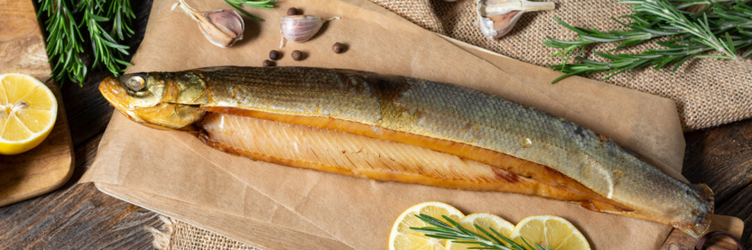 Smoked omul. Smoked fish omul lies on a wooden table. The view from the top. Banner