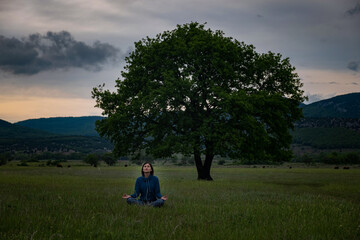 A young woman doing yoga in the field.