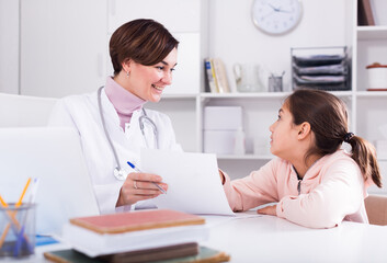 Obraz premium Therapist shows and tells about necessary medical procedures to teenage girl