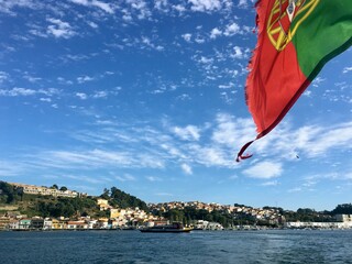 A worn out Portuguese flag and a panoramic view of a small Portuguese village