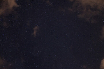 Obraz na płótnie Canvas Sterne am bewölkten Nachthimmel, lila Wolken