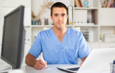Male doctor is ready to receive patients in the office of a medical clinic