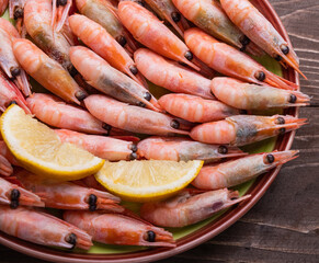 Freshly cooked prawns in a plate on a wooden table. Close up.