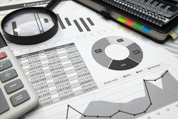 business office desk closeup - financial reports, analysis and accounting, set of documents, tables and graphs, various items for bookkeeping, calculator