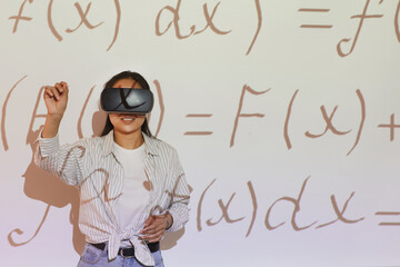 Smiling Asian student girl in casual shirt gesturing hand while solving virtual equation using...