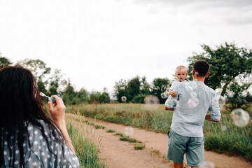 A happy family walks with a child in nature