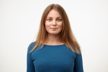 Obraz premium Portrait of attractive young white-headed female with natural makeup smiling gently while looking positively at camera, isolated over white background