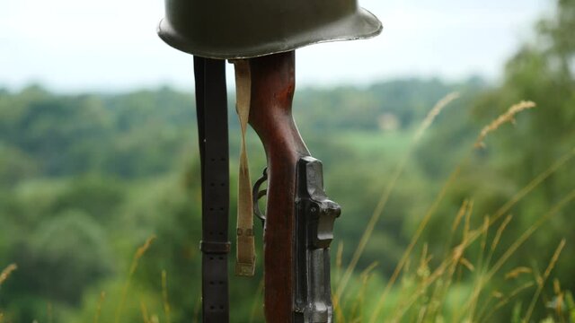 Memorial battlefield cross. Symbol of a fallen US soldier. M1 rifle with helmet.