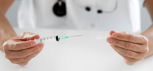 Syringe in the hand of a woman doctor