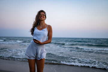 Fototapeta na wymiar Woman on island summer vacations listening to music on beach