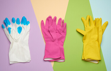 three pairs of protective rubber gloves on a colored background
