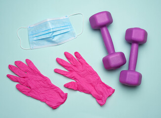 plastic dumbbells, a medical mask and pink latex gloves