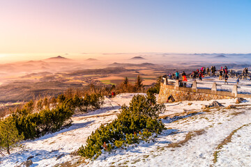 Lookout terrace at Jested Mountain Hotel. Sunny winter day view of tourists and foggy landscape. Liberec, Czech Republic