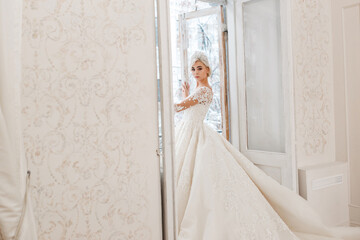 Bride in white dress, blonde girl posing in a photo studio. Vintage style interior.