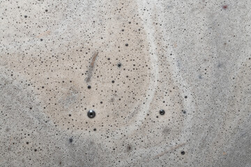 White lemna with foam in puddle after heavy rain