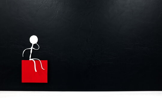 Human stick figure sitting alone while thinking in black background with copy space. Curiosity and solitude concept.