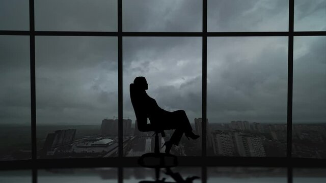 The business woman is spinning in the chair on the rainy sky background