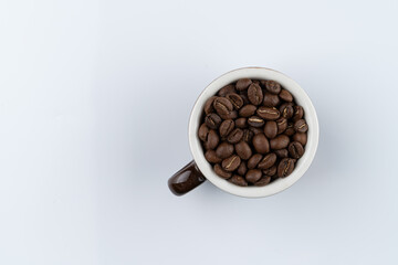 Bali kopi coffee beans in a cup, directly above, isolated on white