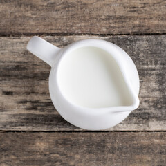 Organic milk in a milk jugn on a wooden background in rustic style.