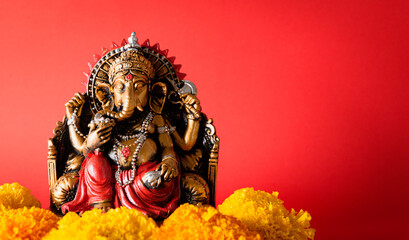 Happy Ganesh Chaturthi festival, Bronze Ganesha statue and Golden texture with flowers, Ganesh is hindu god of Success.