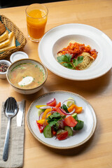 Lunch in a cafe: summer salad, pasta and mushroom cream-soup