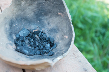 The cooled coals in a clay pot. Nature, background, or texture.