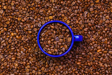 Blue tin mug full of coffee beans.