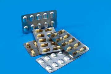 Close up of medical blister packs with tablets on a dark blue background. Packs with various pills. The concept of the threat of various diseases.