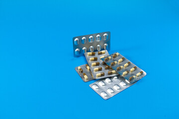 Medical blister packs with tablets on a dark blue background. Packs with various pills. The concept of the threat of various diseases.