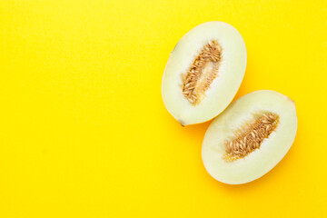 Cut ripe melon isolated on yellow background. Copy space for text.