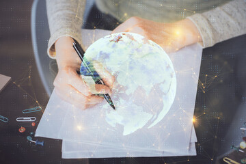 Social network theme hologram over hands taking notes background. Concept of global international people connect. Double exposure