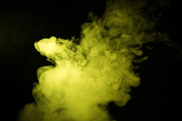 Colorful smoke close-up on a black background. Yellow cloud of smoke.