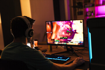 Image of focused man in headphones playing video game on computer © Drobot Dean