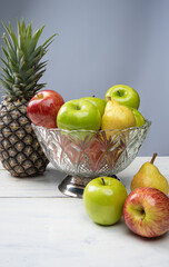 fruits in an arrangement on a white wooden surface with a white background. selective focus.