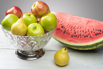 fruits in an arrangement on a white wooden surface with a white background. selective focus.