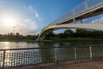 View of bridge over canal, with summer sunset, in a park in Madrid, Spain, horizontal