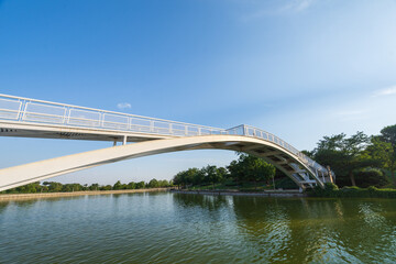 View of bridge over canal at sunset in summer, in Juan Carlos I park in Madrid, Spain, horizontal