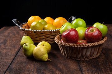 fruits arranged on a rustic wooden surface with a black background. selective focus.