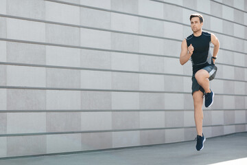 Fototapeta na wymiar Active lifestyle. Guy athlete in sportswear runs with jumps