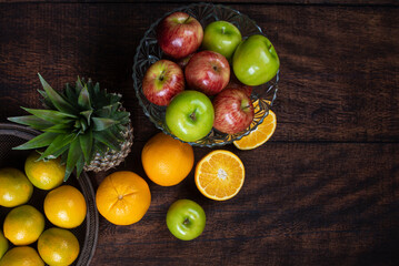 fruits arranged on a rustic wooden surface with a black background. top view.